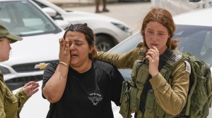 An Israeli soldier cries outside a military base following a deadly shootout in southern Israel along the Egyptian border, Saturday, June 3, 2023. (AP Photo/Tsafrir Abayov)