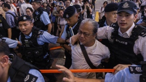 A member of the public is taken away by the police in the Causeway Bay area on the eve 34th anniversary of China's Tiananmen Square massacre in Hong Kong, Saturday, June 3, 2023. (AP Photo/Louise Delmotte)