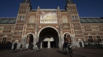 Cyclists pass under the Vermeer exhibit sign at Amsterdam's Rijksmuseum, Monday, Feb. 6, 2023. The blockbuster exhibition of paintings by Dutch Master Johannes Vermeer closed its doors for the final time Sunday, June 4, with the art and history national museum of the Netherlands hailing the show as its most successful ever. (AP Photo/Peter Dejong, file)