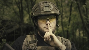 In this image made from video provided by Ukrainian Defense Ministry on Sunday, June 4, 2023, a Ukrainian soldier poses for the camera with his fingers to his lips, in an undisclosed location in Ukraine. A video released by the Ukrainian Defense Ministry on Sunday shows its military gesturing to silence suggesting that no formal announcement of a possible counter offensive against Russia will be made. The on-screen text of the video reads "Plans love silence. There will be no announcement of the start." (Ukrainian Defense Ministry via AP)
