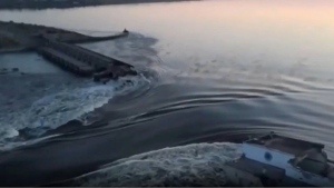 In this image taken from video released by the Ukrainian Presidential Office, water runs through a breakthrough in the Kakhovka dam in Kakhovka, Ukraine, Tuesday, June 6, 2023. Ukraine on Tuesday accused Russian forces of blowing up the major dam and hydroelectric power station in a part of southern Ukraine they control, threatening a massive flood that could displace hundreds of thousands of people, and ordered residents downriver to evacuate. (Ukrainian Presidential Office via AP)