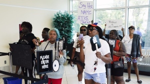 Protesters gather in the lobby of the Marion County Courthouse, Tuesday, June 6, 2023, in Ocala, demanding the arrest of a woman who shot and killed Ajike Owens, a 35-year-old mother of four, last Friday night, June 2. Authorities came under intense pressure Tuesday to bring charges against a white woman who killed Owens, a Black neighbor, on her front doorstep, as they navigated Florida’s divisive stand your ground law that provides considerable leeway to the suspect in making a claim of self defense. (AP Photo/John Raoux)

