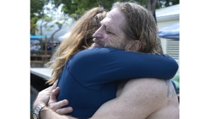 In this photo provided by the Florida Keys News Bureau, diving explorer and medical researcher Dr. Joseph Dituri hugs his lead physician, Dr. Sarah Spelsberg, Friday, June 9, 2023, after living for 100 days in the Jules' Undersea Lodge marine habitat at the bottom of a lagoon in Key Largo, Fla. Dituri broke the previous 73-day record for underwater human habitation at ambient pressure, undertook medical and marine science research and interacted online with more than 5,500 students during his Project Neptune 100 mission organized by the Marine Resources Development Foundation. (Andy Newman/Florida Keys News Bureau via AP)