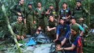 In this photo released by Colombia's Armed Forces Press Office, soldiers and Indigenous men pose for a photo with the four Indigenous brothers who were missing after a deadly plane crash, in the Solano jungle, Caqueta state, Colombia, Friday, June 9, 2023. Colombian President Gustavo Petro said Friday that authorities found alive the four children who survived a small plane crash 40 days ago and had been the subject of an intense search in the Amazon jungle that held Colombians on edge. (Colombia's Armed Force Press Office via AP)
