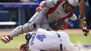 Toronto Blue Jays George Springer (4) dives for home plate and collides with Minnesota Twins catcher Ryan Jeffers (27) during fifth inning American League MLB baseball action in Toronto on Saturday, June 10, 2023. THE CANADIAN PRESS/Arlyn McAdorey