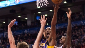 Los Angeles Lakers guard Kobe Bryant, centre, drives the net past Toronto Raptors forward Aaron Gray, left, and Ed Davis, right, during first half NBA basketball action in Toronto on Sunday, January 20, 2013. THE CANADIAN PRESS/Nathan Denette