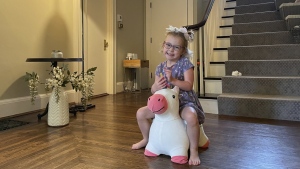 Brynn Schulte rides on a toy unicorn at her home in Cincinnati shortly before getting medication to treat her rare genetic bleeding disorder, Aug. 3, 2023. Brynn was diagnosed thanks to whole genome testing, which was recently shown to be nearly twice as good at finding genetic disorders in sick babies as more targeted tests. Her parents and doctors credit early diagnosis with saving her life. (AP Photo/Laura Ungar)