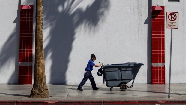 maintenance worker pushes a refuse cart