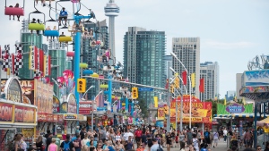 FILE - Crowds make their way through the midway during opening day of the Canadian National Exhibition in Toronto on Friday, August 19, 2022. THE CANADIAN PRESS/Tijana Martin 