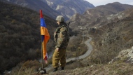 FILE - In this Wednesday, Nov. 25, 2020 file photo, an ethnic Armenian soldier stands guard next to Nagorno-Karabakh's flag atop of the hill near Charektar in the separatist region of Nagorno-Karabakh at a new border with Kalbajar district turned over to Azerbaijan. Azerbaijan has announced an “anti-terrorist operation” targeting Armenian military positions. A statement from the Azerbaijan defense ministry said the operation began hours after four soldiers and two civilians died in landmine explosions in the Nagorno-Karabakh region. (AP Photo/Sergei Grits, File)
