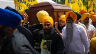 Mourners carry the casket of Sikh community leader and temple president Hardeep Singh Nijjar during Antim Darshan, the first part of day-long funeral services for him, in Surrey, B.C., Sunday, June 25, 2023. THE CANADIAN PRESS/Darryl Dyck