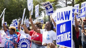 Striking United Auto Workers members cheer and wave their signs as a passing driver honks their horn outside the General Motors Memphis ACDelco Parts Distribution Center and Bulk Center after local workers joined national UAW strikes at 11 a.m. in Memphis, Tenn., on Friday, Sept. 22, 2023. (Chris Day/The Commercial Appeal via AP)