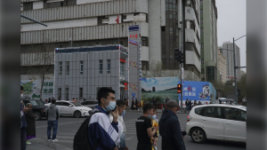 People walk past a police station in Urumqi, the capital of China's far west Xinjiang region, on April 21, 2021. A prominent Uyghur scholar specializing in the study of her people's folklore and traditions has been sentenced to life in prison, according to a U.S.-based foundation that works on human rights cases in China. Rahile Dawut was convicted on charges of endangering state security in December 2018 in a secret trial, the San Francisco-based Dui Hua Foundation said in a statement Thursday, Sept. 21, 2023. (AP Photo/Dake Kang, File)