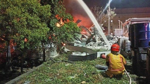 In this image provided by the Pingtung County Government, a firefighter tries to extinguish a fire at a factory of golf ball manufacturer Launch Technologies Co. in the southern county of Pingtung in Taiwan on Friday, Sept. 22, 2023. The factory fire has left multiple people killed, and the victims include several firefighters, according to Taiwanese media reports. (Pingtung County Government via AP)
