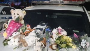 A makeshift memorial is shown on a police car in Laval, Que, Wednesday, Feb. 8, 2023, near the scene where a city bus crashed into a daycare centre leaving two children dead. A Quebec man accused of killing two young children by driving a city bus into a Montreal-area daycare is scheduled to return to court today. THE CANADIAN PRESS/Graham Hughes
