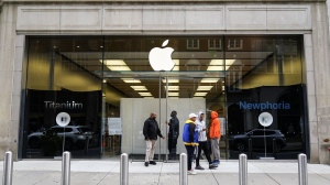 People stand outside an Apple Store in Philadelphia, Wednesday, Sept. 27, 2023 after it was ransacked the previous evening. Police say groups of teenagers swarmed into stores across Philadelphia in an apparently coordinated effort, stuffed bags with merchandise and fled. (AP Photo/Matt Rourke)