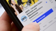 A person navigates to the on-line social-media pages of the Canadian Radio-television and Telecommunications Commission (CRTC) on a cell phone in Ottawa on May 17, 2021. THE CANADIAN PRESS/Sean Kilpatrick