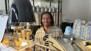 Anteneh Mulu, 46, poses behind the counter after serving a customer at his coffee shop, The Ethiopian Coffee Company, in central London on Thursday, Aug. 31, 2023. Mulu and his business partner Polly Hamilton, 79, opened their shop in 2013. The London-based International Coffee Organization has declared this Sunday, Oct. 1, as International Coffee Day. (AP Photo/Almaz Abedje)