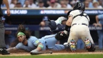Toronto Blue Jays' Bo Bichette, left, is tagged out at home plate by Minnesota Twins catcher Ryan Jeffers on a fielder's choice after an infield single by Kevin Kiermaier during the fourth inning in Game 1 of an AL wild-card baseball playoff series Tuesday, Oct. 3, 2023, in Minneapolis. (AP Photo/Abbie Parr)