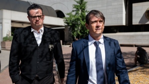 Cameron Jay Ortis, right, a former RCMP intelligence director accused of disclosing classified information, leaves the Ottawa Courthouse following a break in proceedings in Ottawa on Tuesday, Oct. 3, 2023. THE CANADIAN PRESS/Spencer Colby
