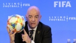FILE - FIFA President Gianni Infantino holds a soccer ball as he speaks during a press conference after the FIFA Council Meeting, Friday, March 15, 2019, in Miami. FIFA is moving more than 100 jobs from its Swiss headquarters to Florida where a growing workforce is already working on organizing the 2026 World Cup. FIFA informed staff Tuesday, Sept. 26, 2023 the entire legal department plus audit, compliance and risk management teams will move from Zurich to Coral Gables near Miami. (AP Photo/Luis M. Alvarez, File)