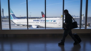 WestJet is halting flights between Toronto and Montreal for the winter. Passengers walk past Air Canada and WestJet planes at Calgary International Airport in Calgary, Alta., Wednesday, Aug. 31, 2022. THE CANADIAN PRESS/Jeff McIntosh