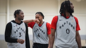 Toronto Raptors' Scottie Barnes (4) jokes with O.G. Anunoby (3) as they stand behind Javon Freeman-Liberty (0) during the opening day of the NBA basketball team's training camp, in Burnaby, B.C., on Tuesday October 3, 2023. THE CANADIAN PRESS/Darryl Dyck