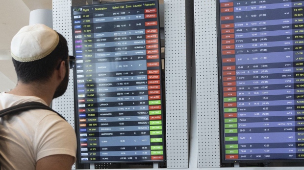 Passengers look at the monitor displaying delayed flights at Ben Gurion airport, near Tel Aviv, Israel, Monday, March 27, 2023. THE CANADIAN PRESS/AP-Oren Ziv