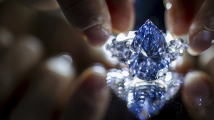 A Christie's employee displays "Bleu Royal," a rare 17.61 carats internally flawless fancy vivid blue pear shaped diamond, during a preview at the Christie's, in Geneva, Switzerland, Thursday, Nov. 2, 2023. The “Bleu Royal” sold at auction Tuesday, Nov. 7, for more than $44 million, far outstripping the pre-sale estimate, Christie's said. (Martial Trezzini/Keystone via AP)