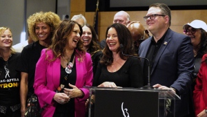 SAG-AFTRA President Fran Drescher, center with National Executive Director and Chief Negotiator Duncan Crabtree-Ireland, right, joined by the TV/Theatrical Negotiating Committee members celebrate after a news conference at the SAG-AFTRA offices in Los Angeles on Friday, Nov. 10, 2023. (AP Photo/Richard Vogel)