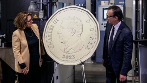 Marie Lemay, President and CEO of the Royal Canadian Mint, and designer Steven Rosati unveil a coin at an event celebrating the first strike of a Loonie with the effigy of King Charles on it at the Royal Canadian Mint in Winnipeg on Tuesday, November 14, 2023. THE CANADIAN PRESS/John Woods