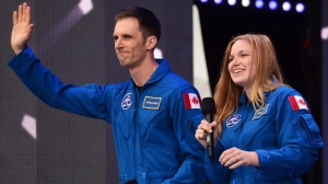 FILE- Canadaian astronauts Joshua Kutryk and Jennifer Sidey acknowledge the crowd during Canada 150 celebrations on Parliament Hill in Ottawa on Saturday, July 1, 2017. Kutryk has been assigned to a six-month mission that will launch no earlier than the beginning of 2025. (THE CANADIAN PRESS/ Sean Kilpatrick)