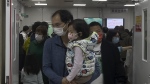 A man carriers a child walk out from a crowded holding room of a children's hospital in Beijing on Oct. 30, 2023. A surge in respiratory illnesses across China that has drawn the attention of the World Health Organization is caused by the flu and other known pathogens and not by a novel virus, the country's health ministry said Sunday, Nov. 26, 2023. (AP Photo/Andy Wong)