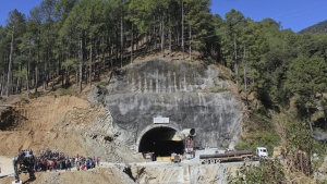 FILE- People watch rescue and relief operations at the site of an under-construction road tunnel that collapsed in mountainous Uttarakhand state, India, Wednesday, Nov. 15, 2023. Officials in India say rescuers are 5 meters (about 16.4 feet) away from the 41 construction workers who have been trapped for over two weeks, raising hopes they may be freed soon. The tunnel the workers were building is part of the Chardham all-weather road, a flagship federal project connecting various Hindu pilgrimage sites. (AP Photo/File)
