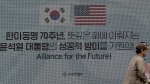 FILE - A passerby walks in front of a huge screen in Seoul, South Korea, on April 25, 2023. The parts of the letters read "the 70th anniversary of the South Korea-U.S. alliance, " and "Wish for South Korean President Yoon Suk Yeol's successful visiting to the United States." (AP Photo/Lee Jin-man, File)