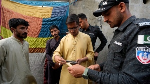 Pakistani police officers conducts biometric identification of a resident during a search operation against illegal immigrants at a neighbourhood of Karachi, Pakistan, Tuesday, Nov. 21, 2023. (AP Photo/Fareed Khan)