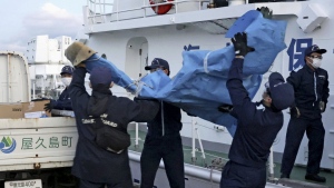 The members of Japanese Coast Guard carry the debris which are believed to be from the crashed U.S. military Osprey aircraft, at a port in Yakushima, Kagoshima prefecture, southern Japan, Monday, Dec. 4, 2023. Japanese and American military divers have spotted what could be the remains of a U.S. Air Force Osprey aircraft that crashed last week off southwestern Japan and several of the six crewmembers who are still missing, local media reported Monday.(Kyodo News via AP)
