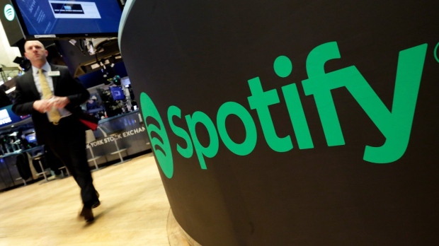 FILE - A trading post sports the Spotify logo on the floor of the New York Stock Exchange, Tuesday, April 3, 2018. Spotify said Monday, Dec. 4, 2023 it's axing 17% of its global workforce, in the music streaming service's third round of layoffs this year as it tries to slash costs while focusing on profitabilty. (AP Photo/Richard Drew, File)
