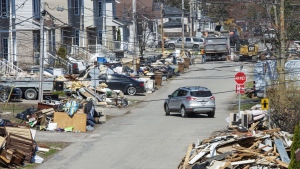 After a dike broke debris lines a street as clean up continues in parts of Ste.Marthe-sur-la-Lac, Que., Monday, May 6, 2019.  THE CANADIAN PRESS/Ryan Remiorz
