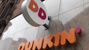 The Dunkin' logo is seen on a storefront, Friday, Oct. 14, 2022, in Boston. A customer in central Florida has filed a negligence lawsuit against Dunkin', claiming he was injured from an exploding toilet at one of the coffee chain's locations. (AP Photo/Michael Dwyer, File)
