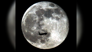 A jet plane passes in front of the supper full moon Sunday night in Monterey Park, Calif. June 23, 2013. (AP Photo/Nick Ut) 