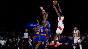 Toronto Raptors guard Immanuel Quickley (5) passes the ball over New York Knicks forward Precious Achiuwa (5) and forward OG Anunoby (8) during the first half of an NBA basketball game in New York, Saturday, Jan. 20, 2024. (AP Photo/Peter K. Afriyie)