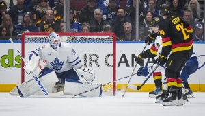 Vancouver Canucks' Elias Pettersson, back right, scores against Toronto Maple Leafs goalie Martin Jones during the third period of an NHL hockey game in Vancouver, on Saturday, January 20, 2024. THE CANADIAN PRESS/Darryl Dyck
