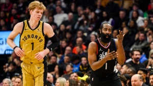 Los Angeles Clippers guard James Harden (1) celebrates after a basket while Toronto Raptors guard Gradey Dick (1) looks on during second half NBA basketball action, in Toronto on Friday, January 26, 2024. THE CANADIAN PRESS/Christopher Katsarov