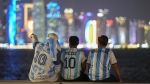 Fans of Argentina sit on Doha corniche, in Doha, Qatar, Monday, Dec. 12, 2022. Toronto and Vancouver are set to get a tourism boost from the World Cup, but experts warn to be wary of rosy projections. THE CANADIAN PRESS/AP-Andre Penner