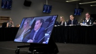 Mirko Bibic, president and CEO of BCE and Bell Canada is seen on television screens as he speaks during a CRTC hearing in Gatineau, Que., on Wednesday, Feb. 19, 2020. Members of Parliament have invited several top executives from BCE Inc. and Bell Canada to testify later this month about the company's decision to cut about nine per cent of its workforce this year. THE CANADIAN PRESS/Justin Tang