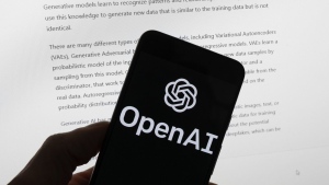 FILE - The OpenAI logo is seen on a mobile phone in front of a computer screen displaying output from ChatGPT, March 21, 2023, in Boston. On Thursday, Feb. 15, 2024, the maker of ChatGPT unveiled its next leap into generative artificial intelligence with a tool that instantly makes short videos in response to written commands. (AP Photo/Michael Dwyer, File)