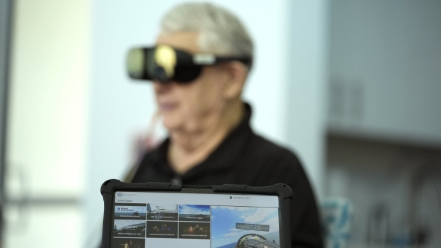 A screen displays a visual of being in a Navy fighter jet as retired Army Col. Farrell Patrick, 91, wears a Mynd Immersive virtual reality headset at John Knox Village, Wednesday, Jan. 31, 2024, in Pompano Beach, Fla. John Knox Village was one of 17 senior communities around the country that participated in a recently published Stanford University study that found that large majorities of 245 participants between 65- and 103-years-old enjoyed virtual reality, improving both their emotions and their interactions with staff. (AP Photo/Lynne Sladky)