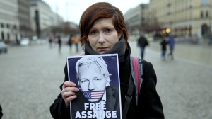 A demonstrator holds a poster during a rally in support of Julian Assange in front of the U.S embassy, in Berlin, Tuesday, Feb. 20, 2024. Assange's lawyers will begin their final U.K. legal challenge on Tuesday to stop the WikiLeaks founder from being sent to the United States to face spying charges. (AP Photo/Ebrahim Noroozi)