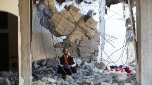 A Palestinian looks at the destruction after an Israeli strike on a residential building in Rafah, Gaza Strip, Wednesday, Feb. 21, 2024. AP Photo/Hatem Ali)